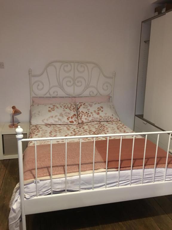 a bed in a room with a white bed frame at Moore Crescent in Barking