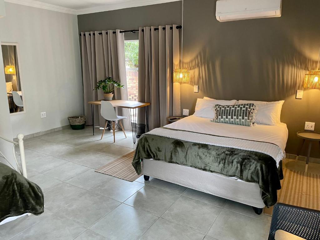 a bedroom with a large bed and a table at 10 Paul Roos in Kimberley