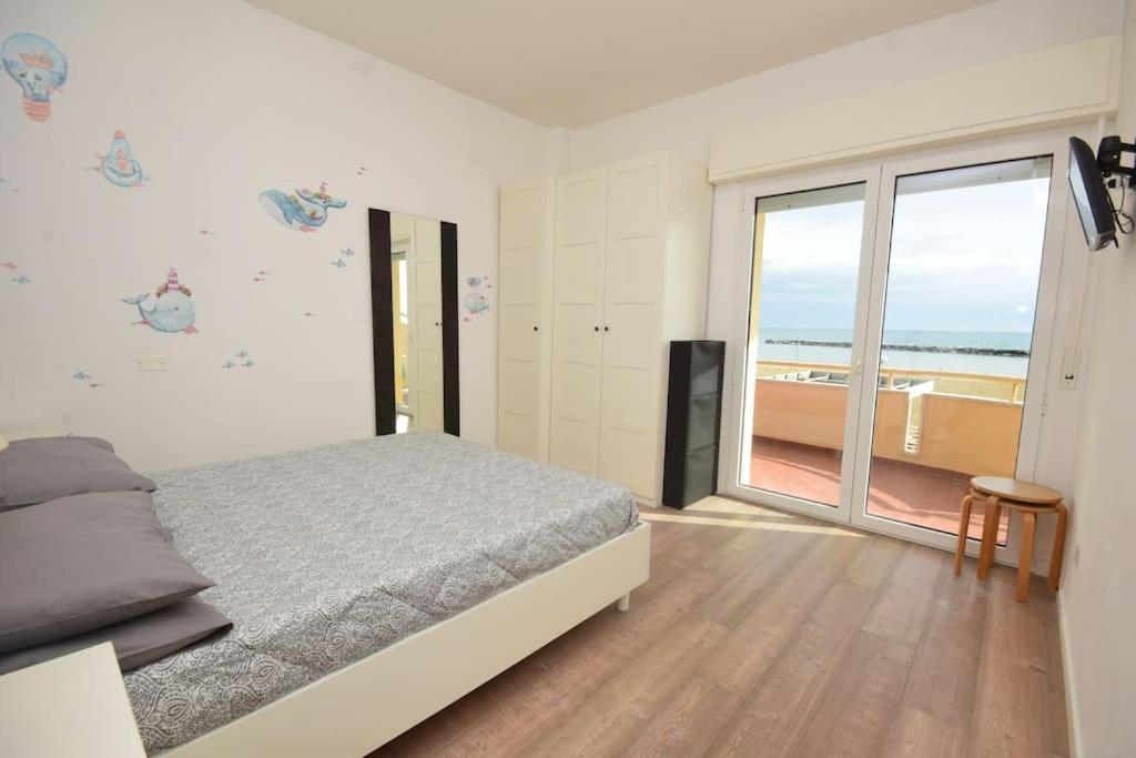 a bedroom with a bed and a view of the ocean at Appartamento Sul Mare - Bellaria in Bellaria-Igea Marina