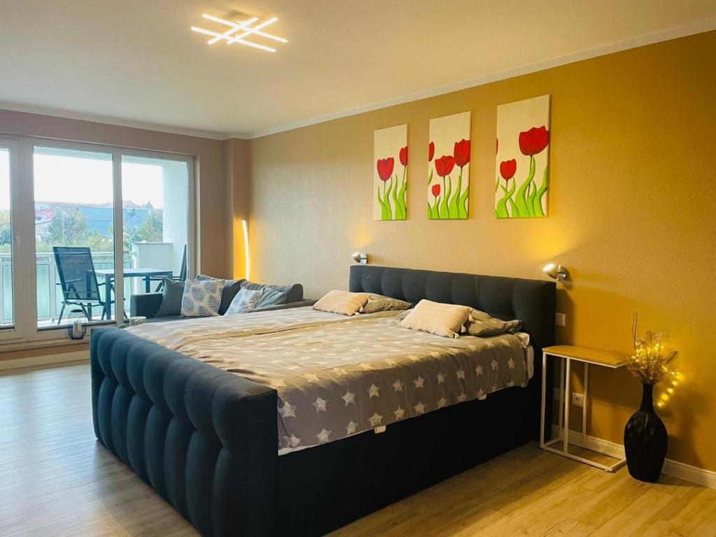 - une chambre avec un grand lit orné de fleurs sur le mur dans l'établissement Strand-Butze 9206 Yachthafenresidenz, à Kühlungsborn