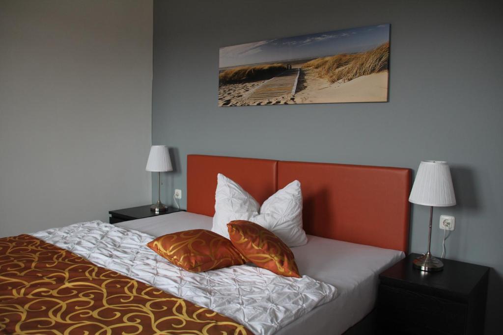 a bedroom with a bed with two pillows on it at Apartmenthaus Unterwegs in Rostock