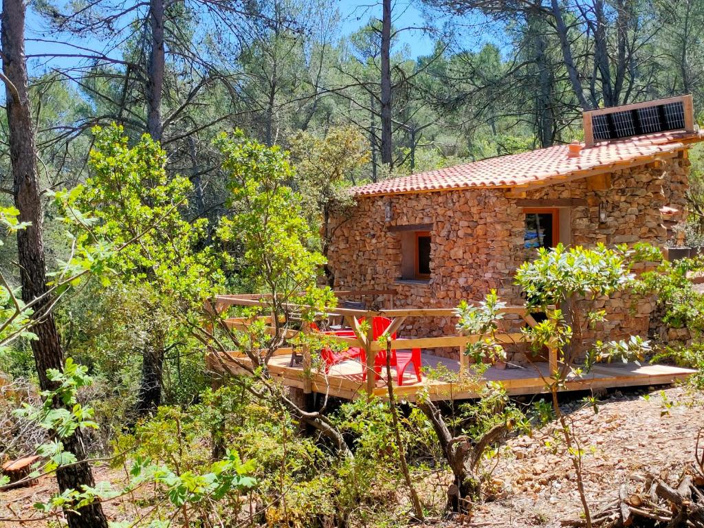 une petite maison en pierre au milieu d'une forêt dans l'établissement Cabane des pachous, à Tourves