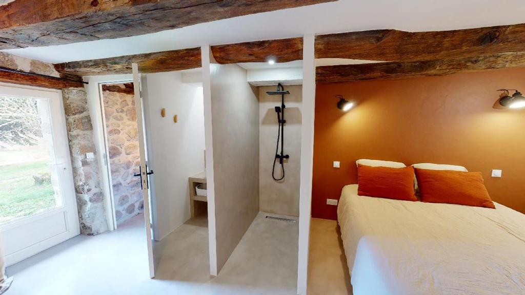 a bedroom with a bed and a glass shower at Une pause en Corrèze in Sarroux
