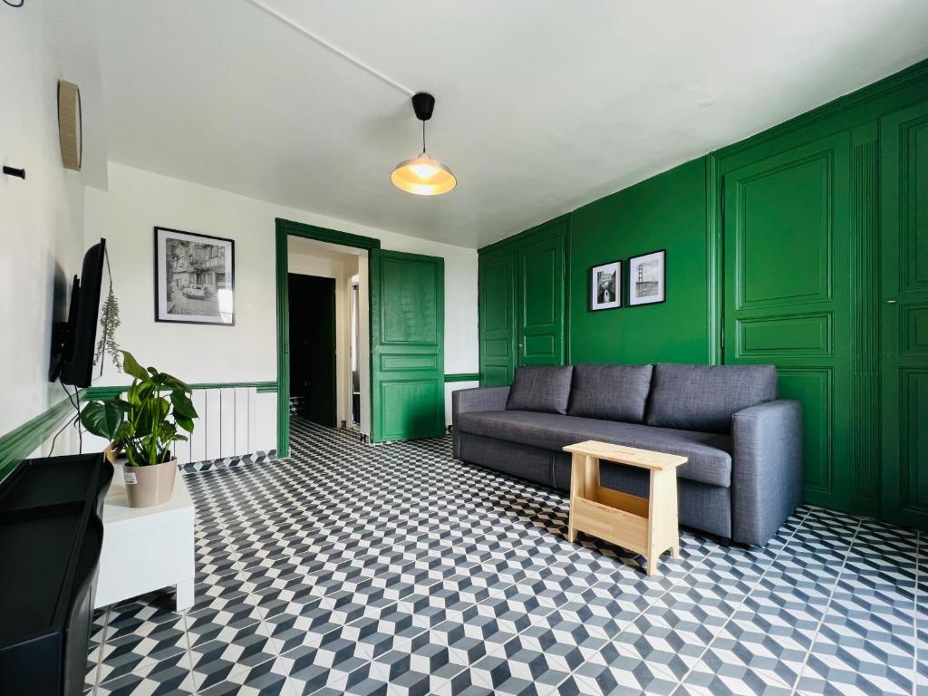 een woonkamer met groene muren en een bank en een tafel bij DnN - Retro 1BR, center Thiers - free wifi and parking - near Vichy, Clermont, Lyon in Thiers