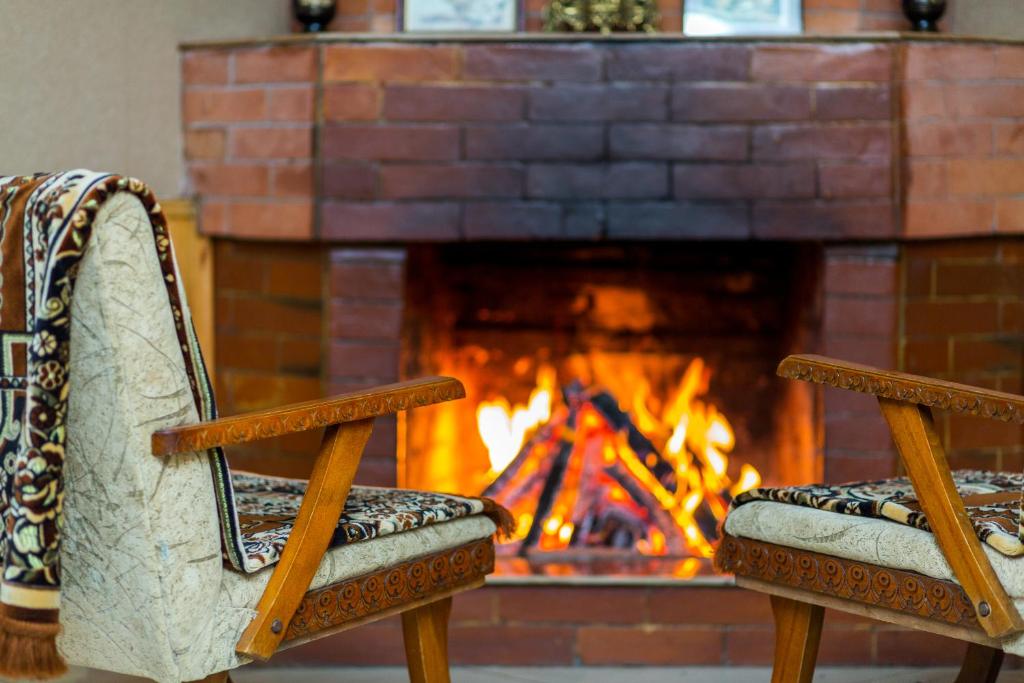 zwei Stühle vor einem Kamin in der Unterkunft Bokneti - Guest House, Agro Tourism Destination in Kʼareli