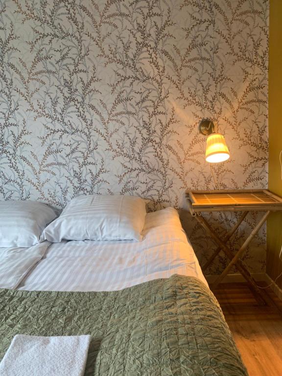 a bedroom with a bed and a table with a lamp at GÆSTEHUSET in Tarm
