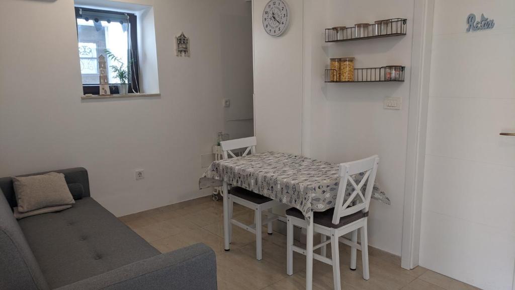 uma sala de estar com uma mesa e um sofá em Apartma Ela em Koper