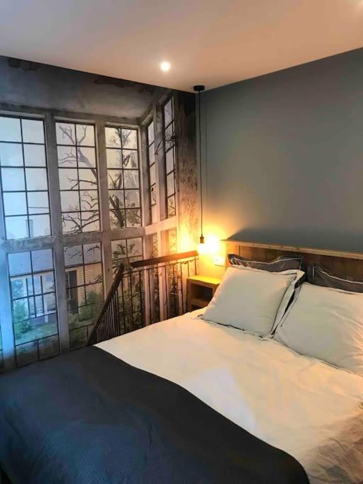 a bedroom with a large bed and a window at Appartement in Meliskerke