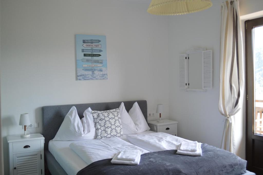 a bedroom with a bed with white sheets and pillows at Jaeger Guesthouse in Annenheim