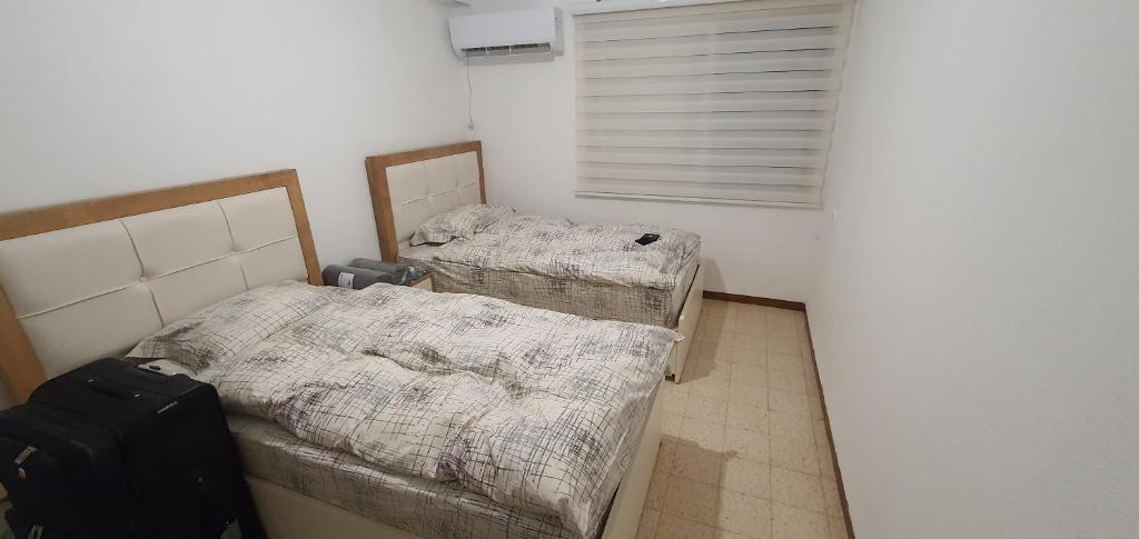 a room with two twin beds and a suitcase at צפת שלי in Safed