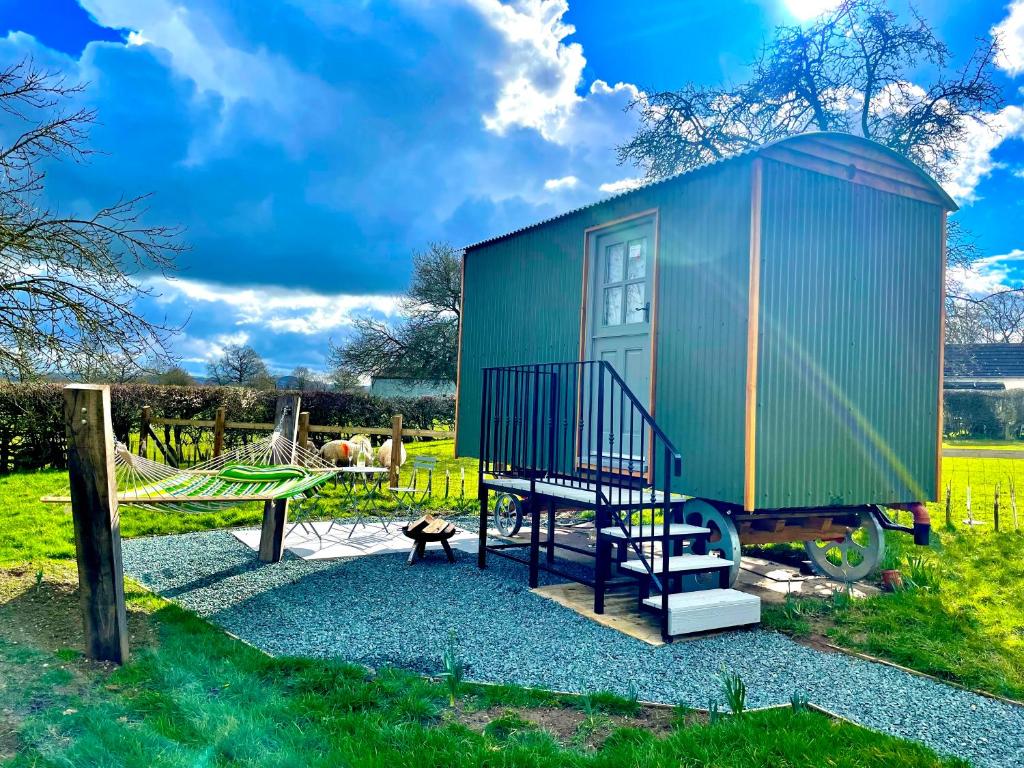 a tiny house with a swing and a playground at The Orchard Retreat in Shrewsbury