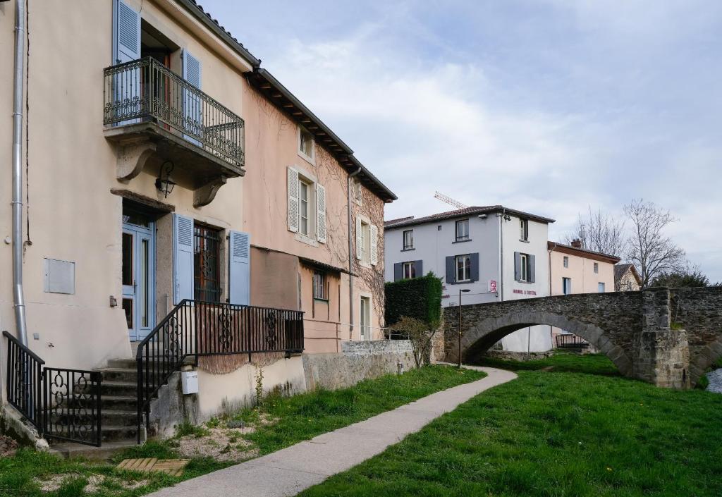 a building with a bridge next to a grass field at Auberge du Vieux Pont in Brignais