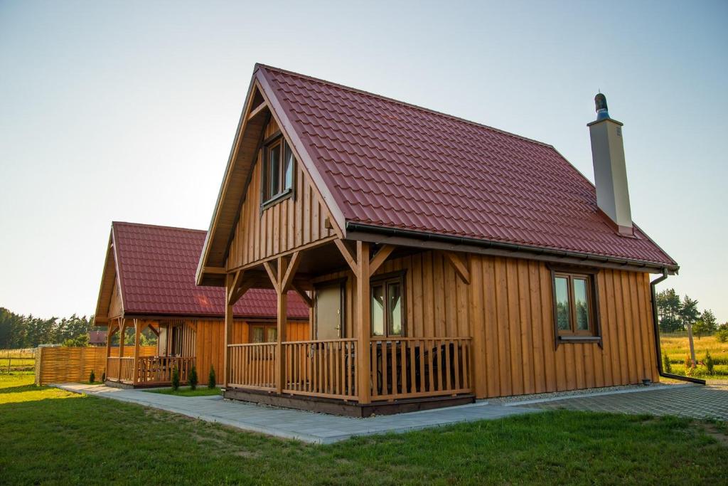 a large wooden house with a red roof at Dreamland skorupki in Ryn