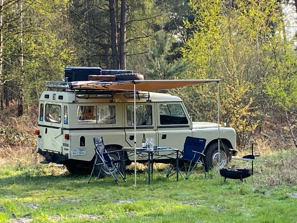 una furgoneta blanca con una mesa y una tabla de surf en la parte superior en DEFCAMP, en Rixensart