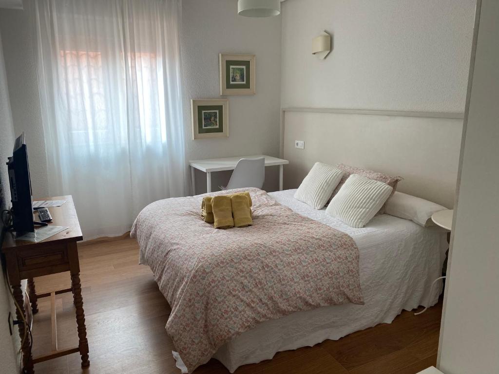 a bedroom with a bed with two pillows on it at Hostería El Cruce in Cabezón de la Sal