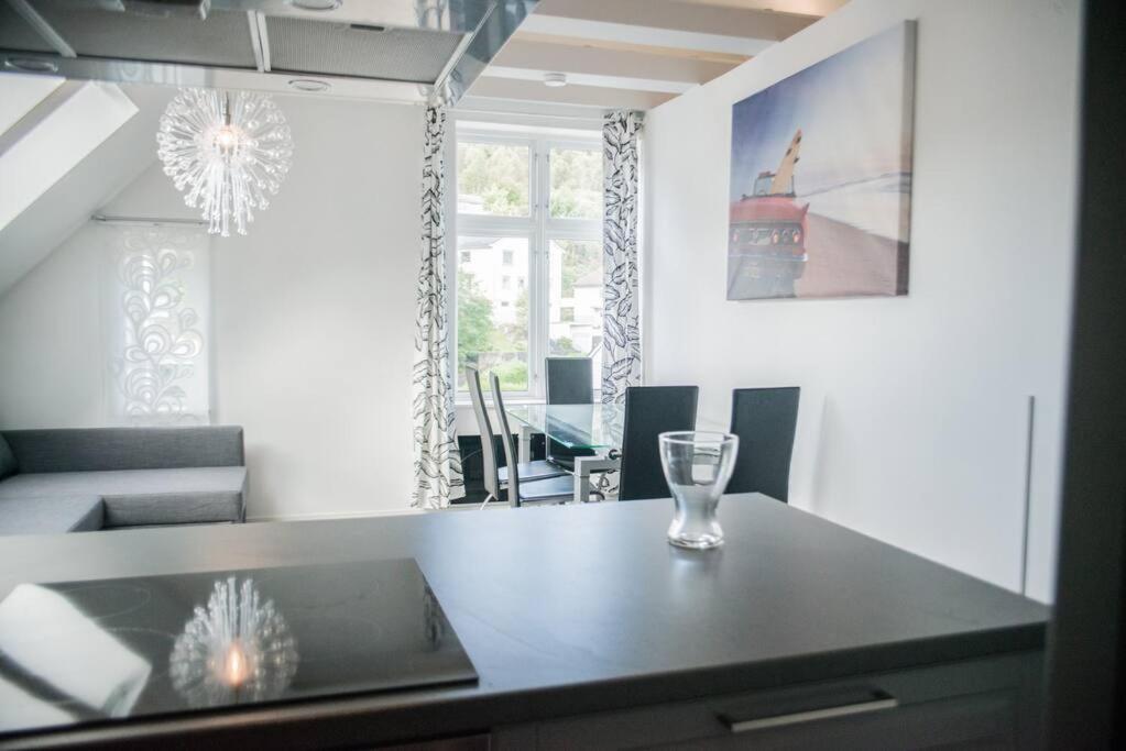 a dining room with a table with a laptop on it at Modern apartment 7 min to center in Bergen