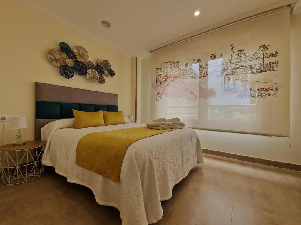 a bedroom with a bed and a large painting on the wall at Magnífico apartamento en el corazón de La Toja in Isla de la Toja