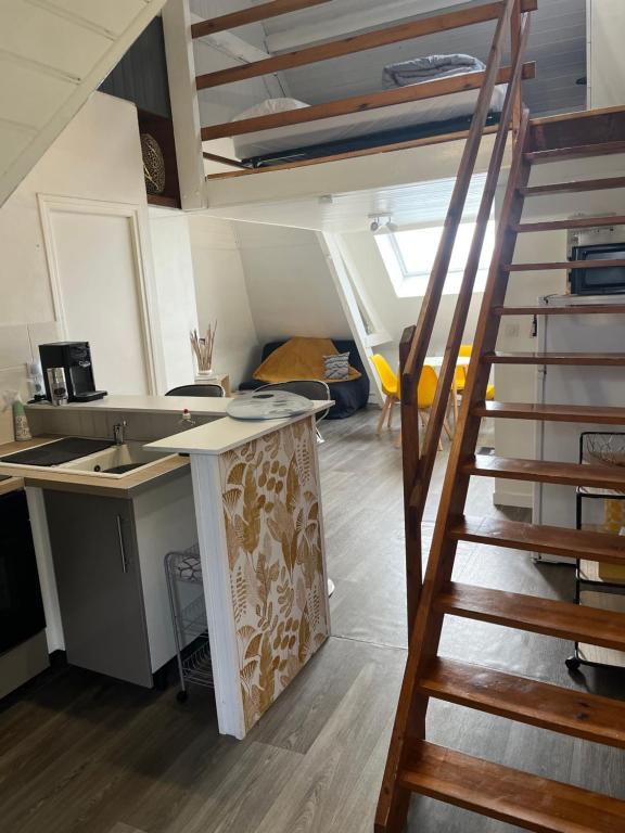 an attic room with a desk and a staircase at Studio Lilouna avec parking privé in Le Tréport