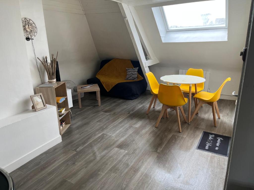 een kamer met een tafel en stoelen en een bed bij Studio Lilouna avec parking privé in Le Tréport