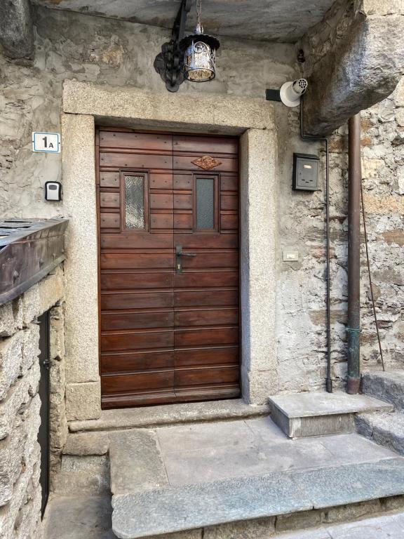 una puerta de madera en el lateral de un edificio de piedra en Ca Angela, en Mergozzo