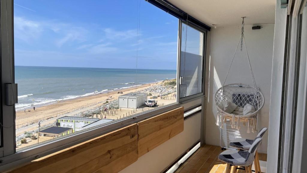 Cette chambre dispose d'une grande fenêtre offrant une vue sur la plage. dans l'établissement Le Dauphin Bleu face mer, à Plage-des-Demoiselles