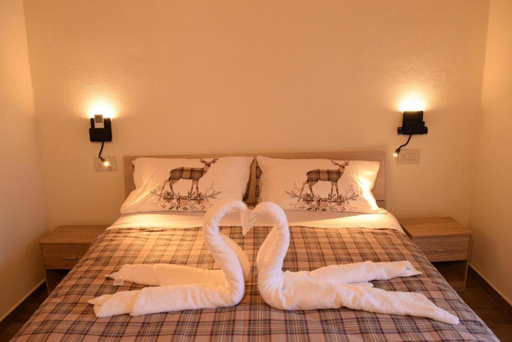 two swans towels on a bed in a bedroom at B&B Da Nora in Mallare