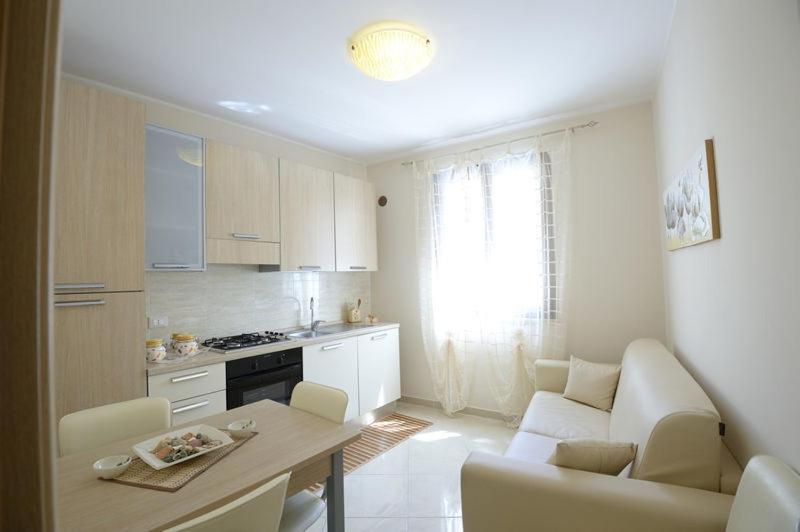 eine Küche mit einem Sofa und einem Tisch in einem Zimmer in der Unterkunft Case Vacanza Edera in Trapani
