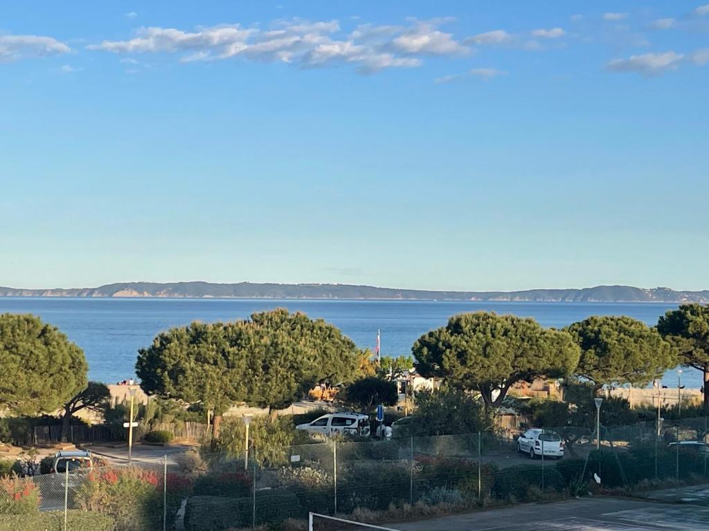 una vista del agua desde un aparcamiento en Appartement pieds dans l’eau Vue Mer Bormes Les Mimosas en Bormes-les-Mimosas