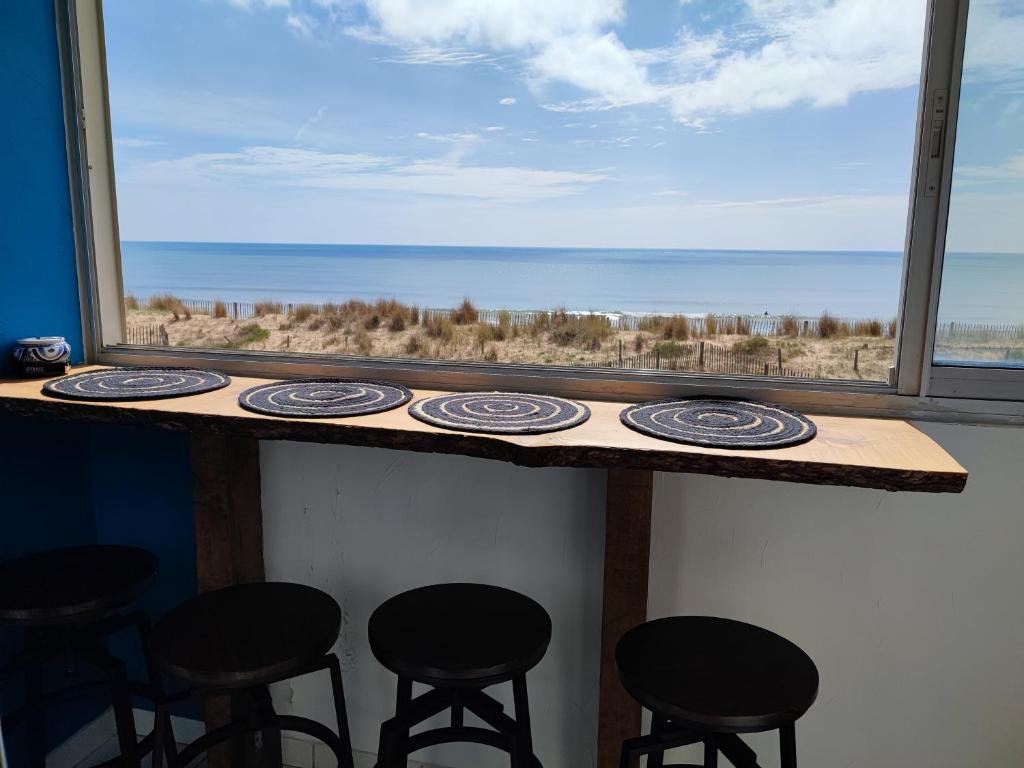 un bar avec vue sur l'océan depuis une fenêtre dans l'établissement Appartement Type 3 face mer, à Saint-Hilaire-de-Riez