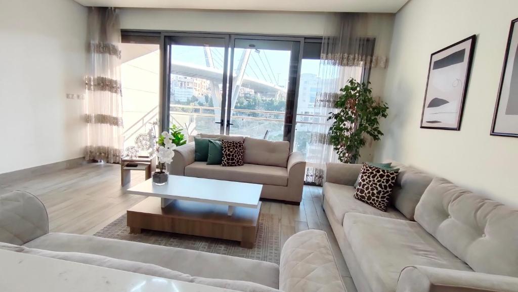a living room with couches and a coffee table at Bridge apartments in Amman