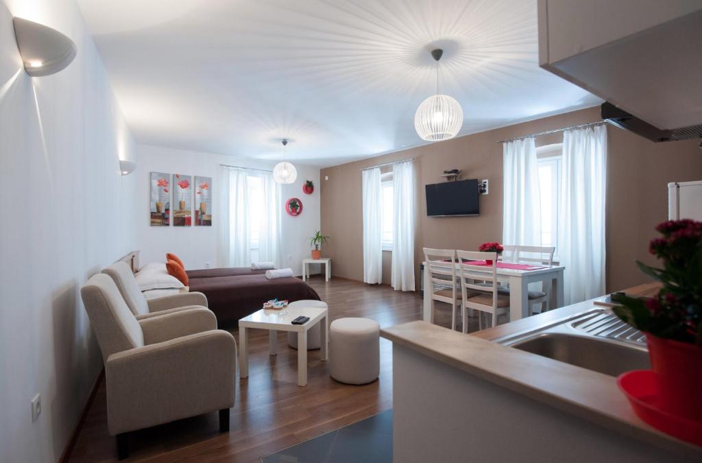 a kitchen and living room with a couch and a table at Rooms & Apartments 72 in Zadar