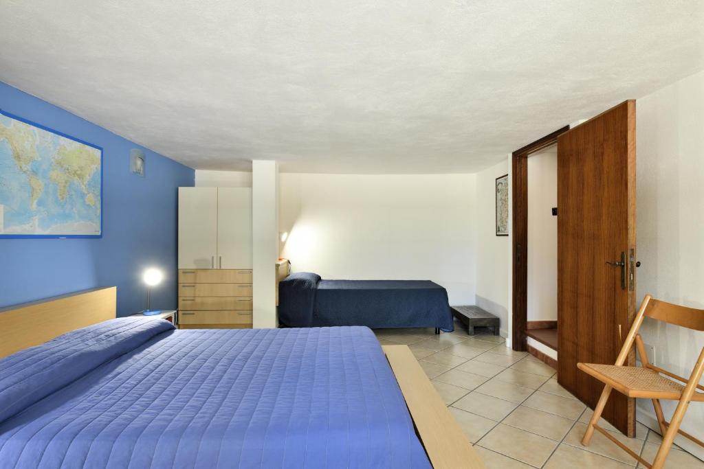 een blauwe slaapkamer met een bed en een stoel bij Casa Oleandri in Santa Maria Navarrese