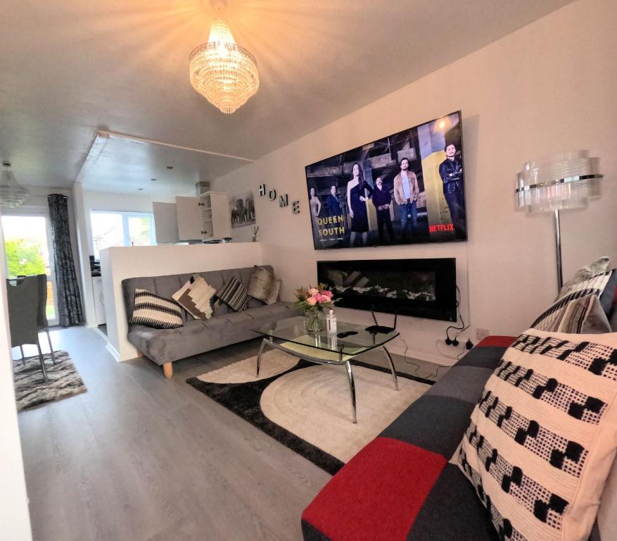 a living room with a couch and a tv at Milton Keynes Luxury Short Stay House with WIFI and Free Parking in Wolverton