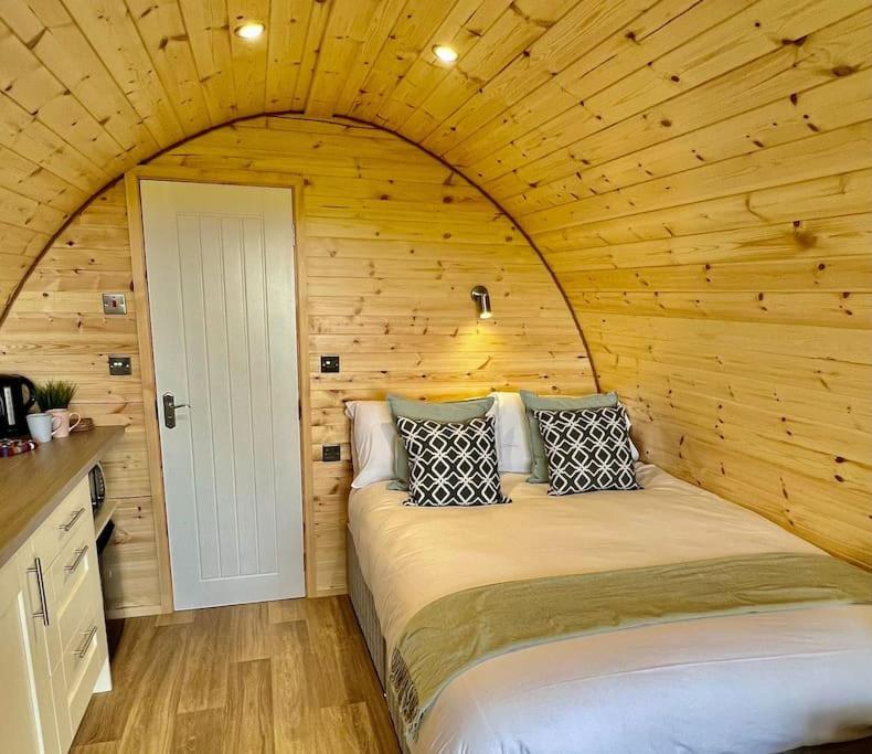 um quarto com uma cama num quarto de madeira em Plumgrove Pod Easkey em Sligo