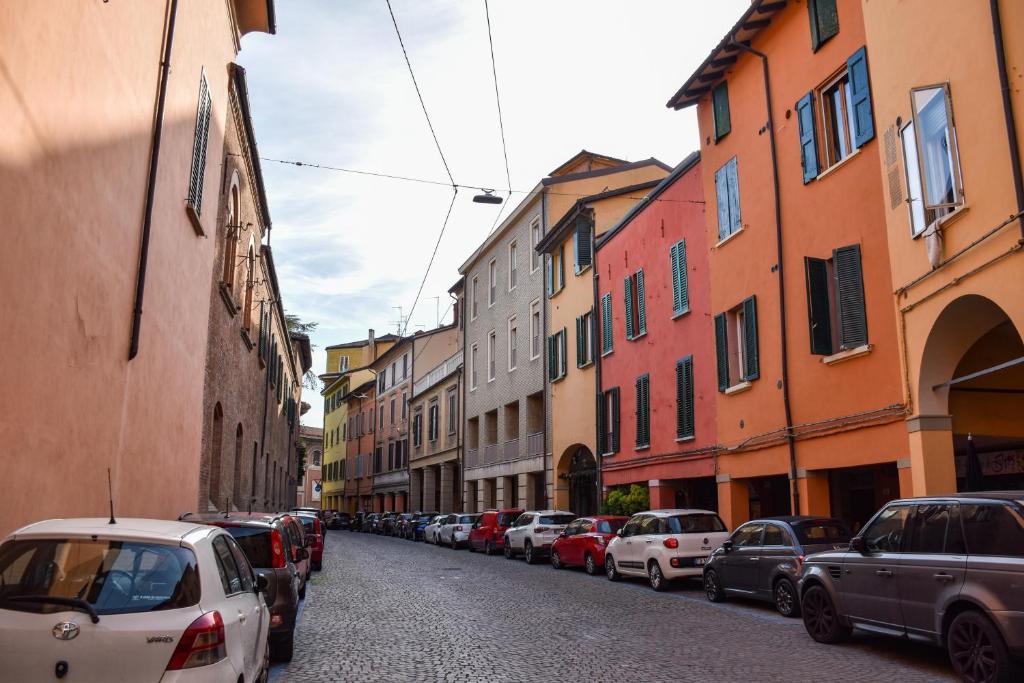 a row of cars parked on a street with buildings at Collegio di Spagna 13 in Bologna