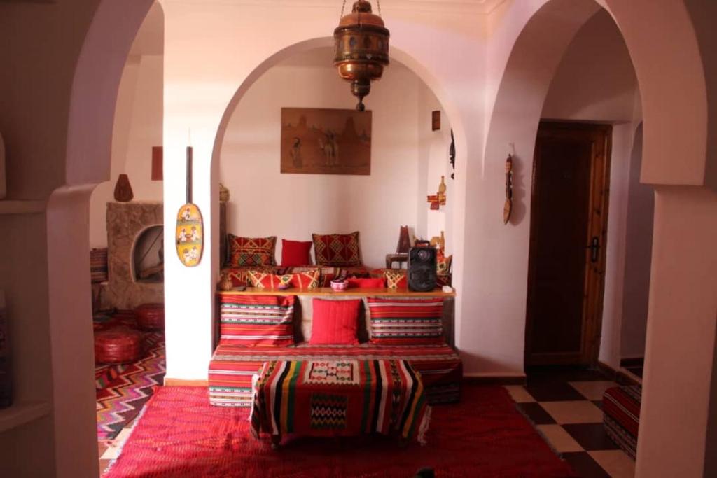 a room with a bed with red pillows on it at DAR EL WAFI in Timimoun