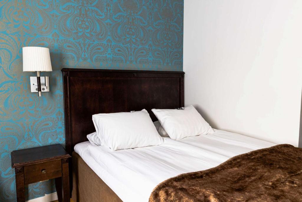 Postel nebo postele na pokoji v ubytování Vimmerby Stadshotell, WorldHotels Crafted