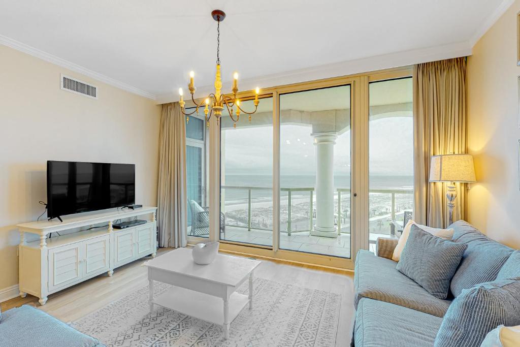 ein Wohnzimmer mit einem blauen Sofa und einem großen Fenster in der Unterkunft Portofino Island Resort & Spa 1-902 in Pensacola Beach