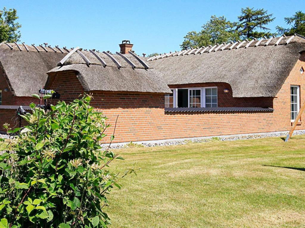 a brick house with a shingled roof at 12 person holiday home in V ggerl se in Marielyst