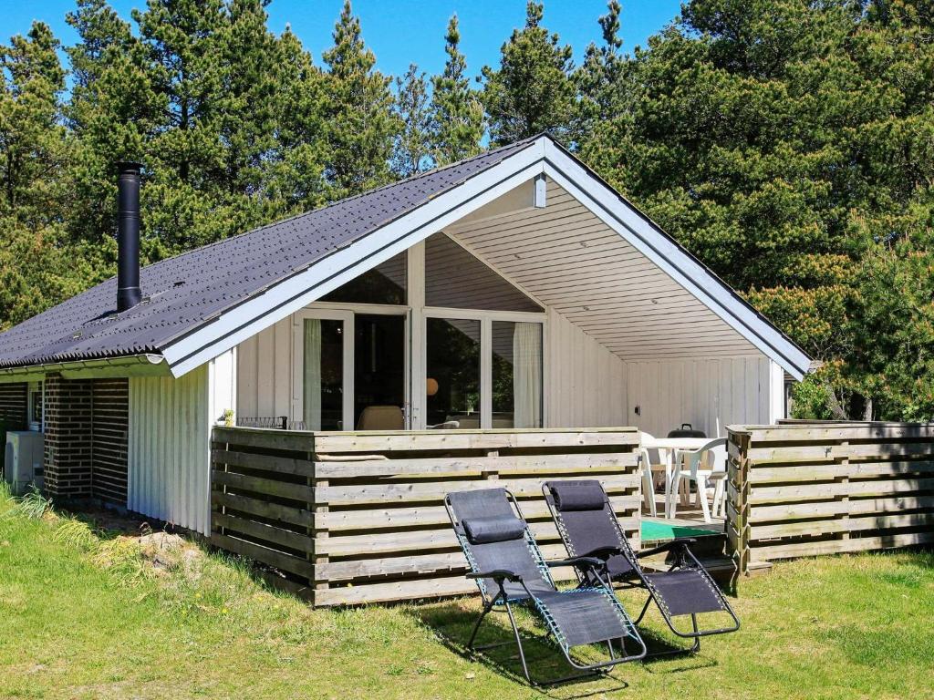 dos sillas sentadas frente a una cabaña en Three-Bedroom Holiday home in Blåvand 16, en Ho