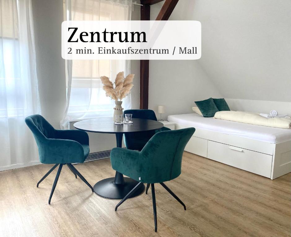 - une salle à manger avec une table et quatre chaises dans l'établissement CITYNA Apartment Bielefeld, à Bielefeld