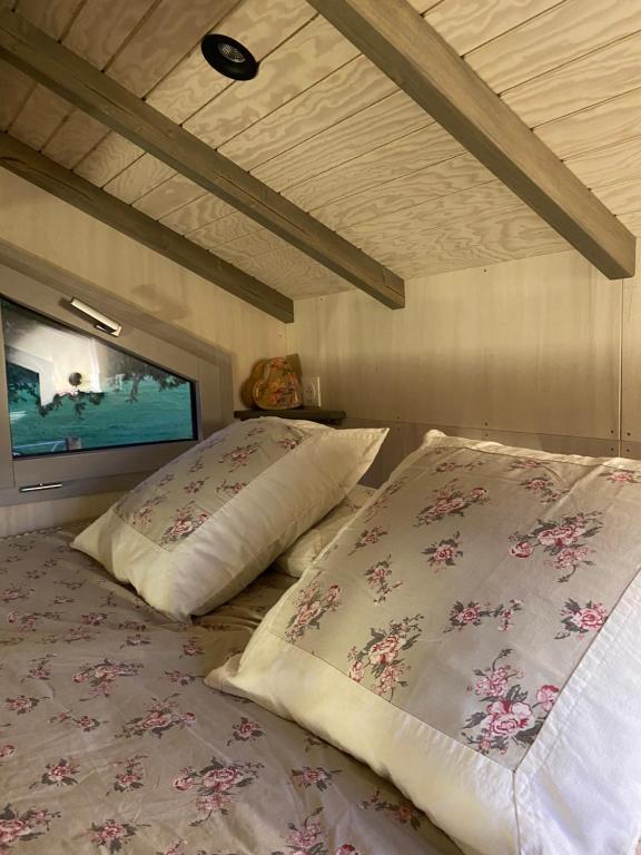 a bedroom with two beds and a tv on the wall at Jolie Tiny House sous les Grands Arbres in Cholet