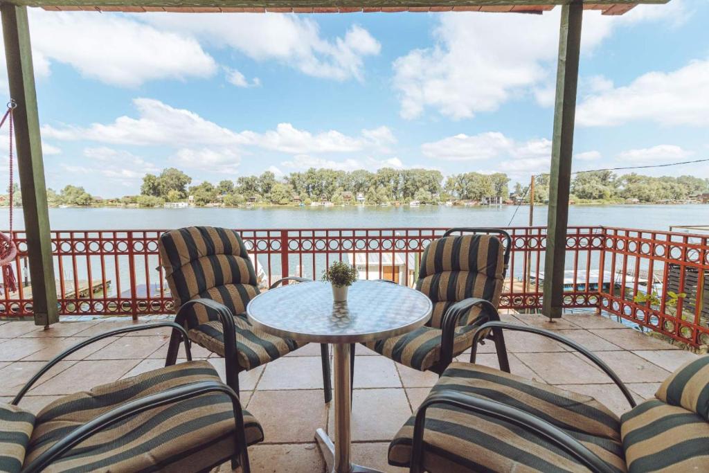 een patio met stoelen en een tafel met uitzicht op het water bij Kuca na Savi in Belgrado