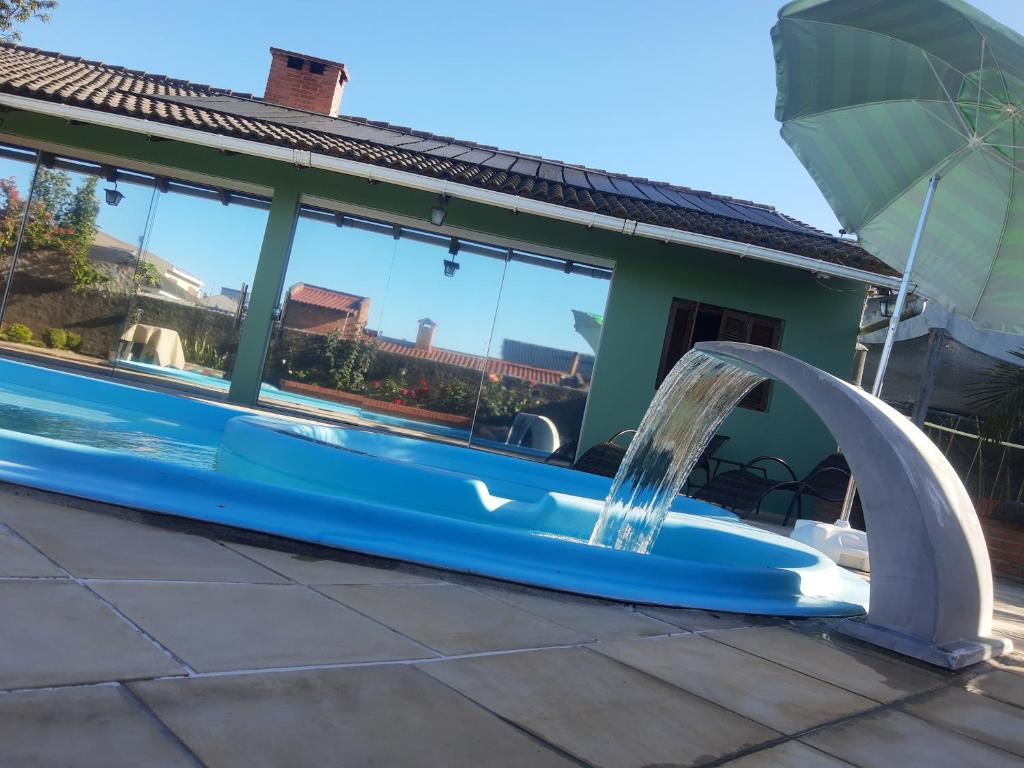 a swimming pool with a water fountain on a patio at Conforto e comodidade em Santa Maria in Santa Maria