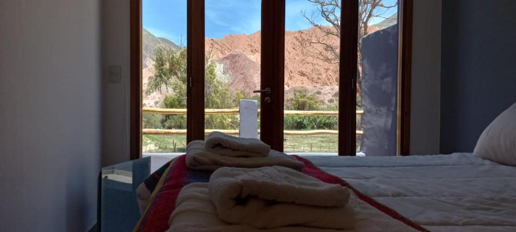 a bedroom with a bed and a window with a view at El cielo en Purmamarca in Purmamarca
