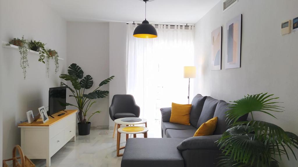 a living room with a couch and a chair at Sherryflat Claveles - Parking in Jerez de la Frontera