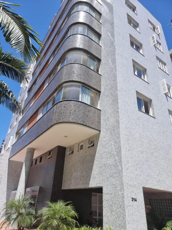 a large concrete building with trees in front of it at Apto 3 Dormitórios, 2 Vagas, Completíssimo, Central, próx Mar in Torres