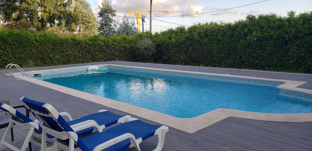 una piscina con sillas azules junto a en Férias felizes em família/com amigos, 