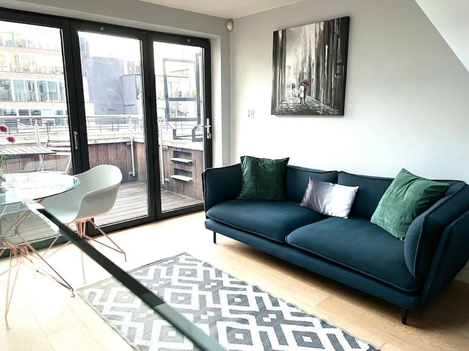 uma sala de estar com um sofá azul e uma mesa em London Duplex Apartment 2 bedroom with Terrace em Londres