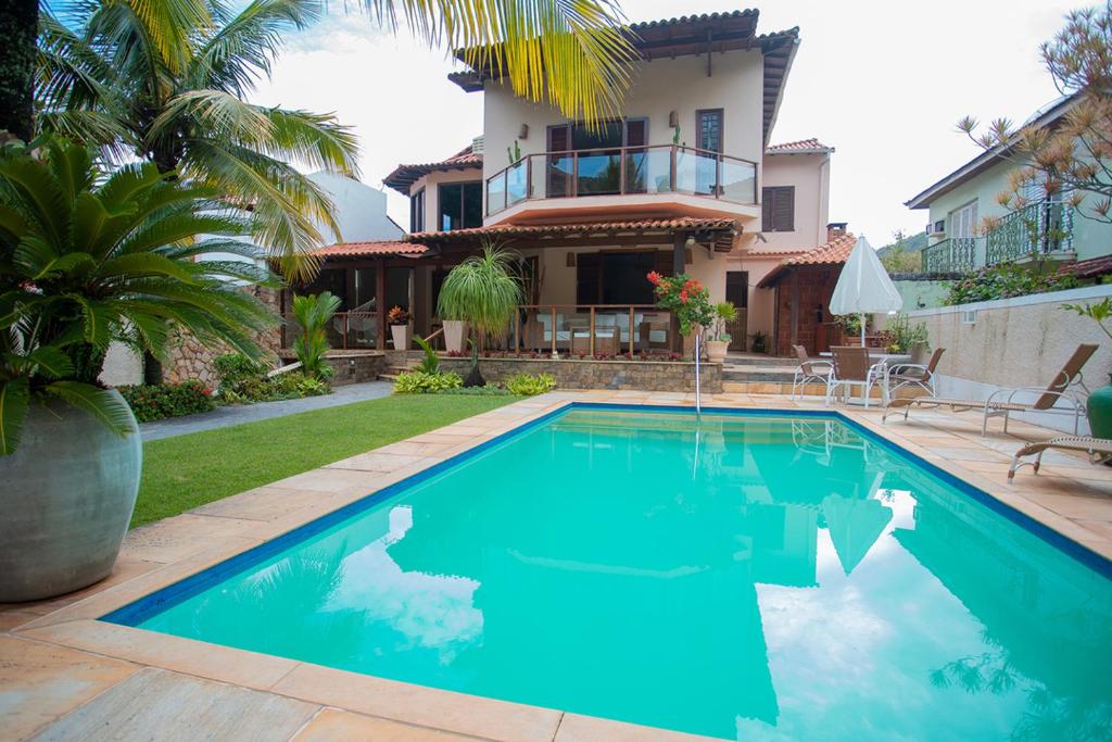 una piscina frente a una casa en Casa a 50m da Praia de Itacoatiara Niteroi RJ en Niterói